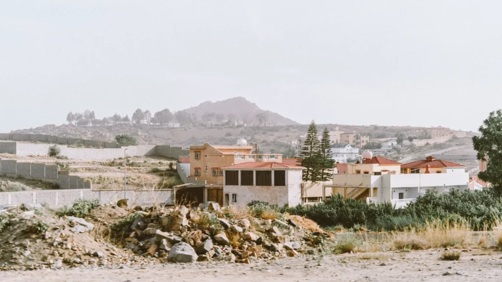 Houses and low hills on the outskirts of Taif under a hazy sky
