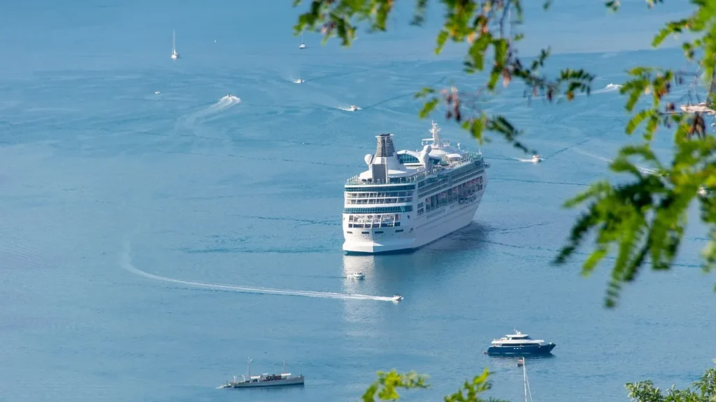 Kreuzfahrtschiff vor Anker in einer blauen Bucht mit kleinen Booten, Ziel für den Hafentransfer zur Kreuzfahrt in Jeddah
