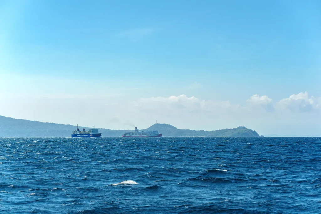 Dos ferris de pasajeros sobre aguas azules con colinas bajas al fondo, una imagen de referencia para el viaje de Yeda a las islas Farasán