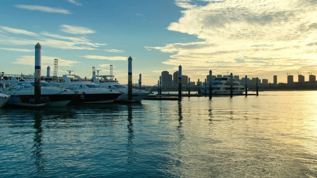 Yachten im Hafen der Marina bei Sonnenuntergang mit der Skyline dahinter, Anfahrt zum Jeddah Yacht Club
