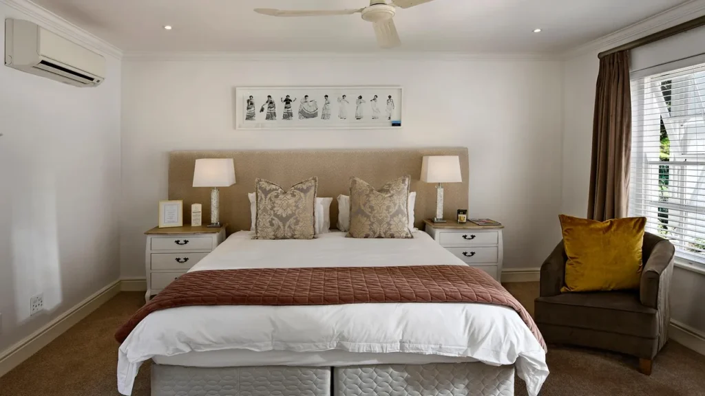 Habitación de hotel preparada con cama de matrimonio, sillón y lámparas de mesilla para la última noche en Yeda antes del vuelo