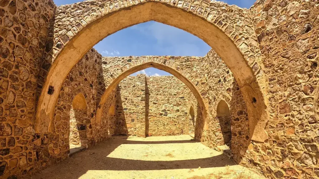 Antiguos arcos y muros de piedra en Taif bajo un cielo azul, destino final de las paradas en la carretera a Taif