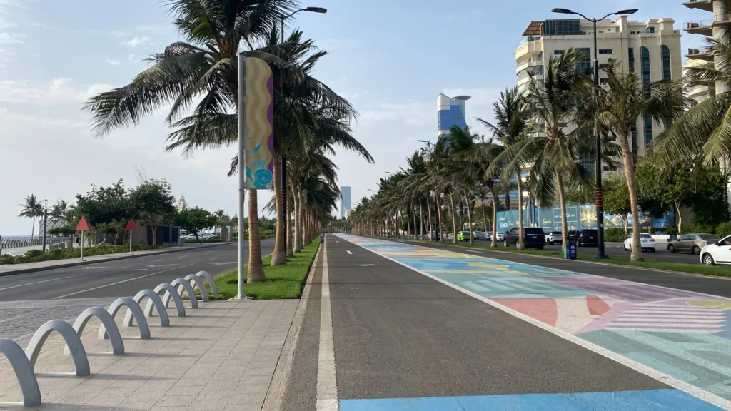 Von Palmen gesäumte Straße mit Radweg entlang der Jeddah Corniche an einem sonnigen Tag