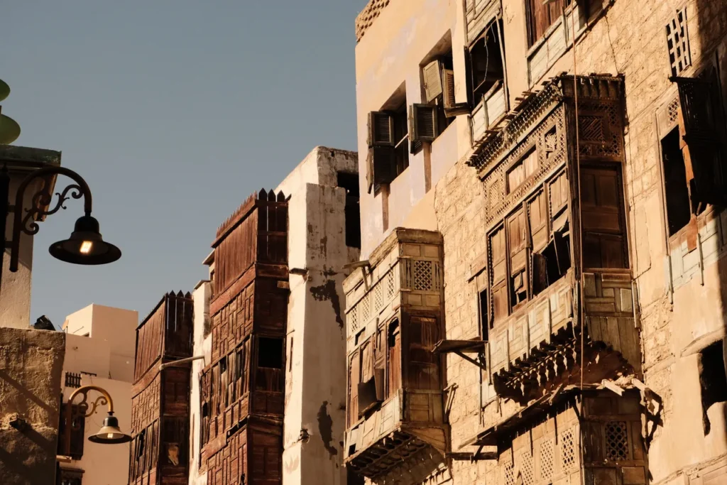 Fachadas de edificios históricos de Yeda con ventanas salientes de madera tallada y farolas, contexto patrimonial para una visita al museo Tayebat de Yeda