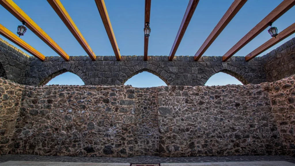 Muro tradicional de piedra con aberturas en arco y vigas de madera en el casco histórico de Yanbu