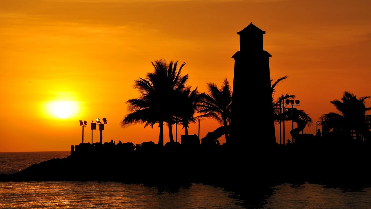 Lighthouse and palms silhouetted at sunset in Jeddah – Jeddah airport taxi